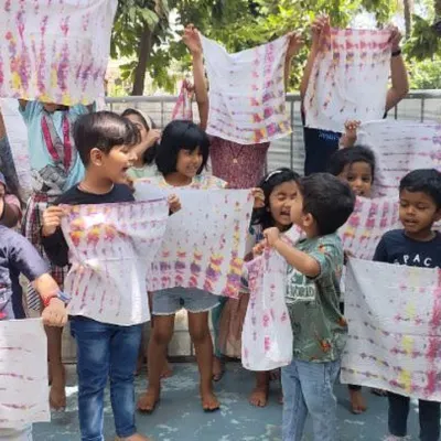 Look what we made! The children proudly display their unique tie-dye creations. This activity is a fantastic way to learn about colors, patterns, and the magic of transformation.