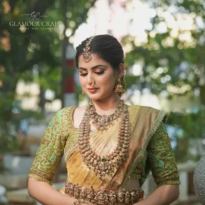 This look showcases a complete antique finish temple jewellery set. I styled the bride with a heavy choker, a long guttapusalu style haar, a matching maang tikka, and a traditional oddiyanam (waist belt) to create a regal bridal profile.