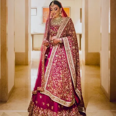 A full-length view of a breathtaking bride in her deep red lehenga. I crafted a classic bridal look with defined eyes and glowing skin to ensure she looked and felt like royalty.
