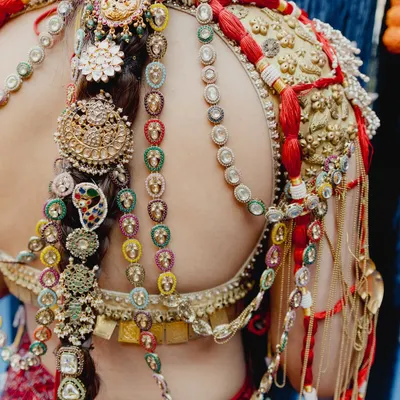 A close-up on the incredible details of this heritage-inspired look. The makeup is flawless, but it's the intricate hair jewelry and blouse embroidery that tell a story of tradition and artistry.
