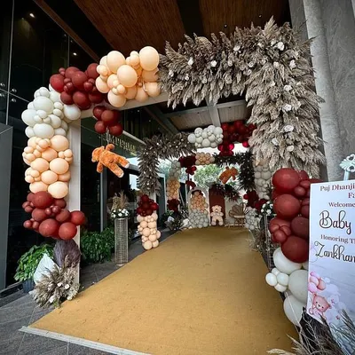 A full view of the grand entrance for a teddy bear themed baby shower, welcoming guests to the celebration. The design combines a massive balloon arch with pampas grass arrangements and a personalized welcome sign.