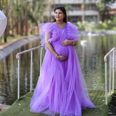 A beautiful lavender ruffled gown, perfect for a dreamy and romantic maternity shoot. The color is soft, and the tulle fabric creates a voluminous, princess-like silhouette.