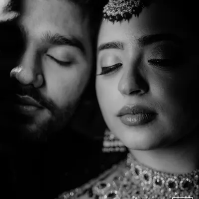 A powerful black and white close-up, where the focus is purely on the emotion and connection. The dramatic lighting adds a cinematic quality to this intimate portrait.