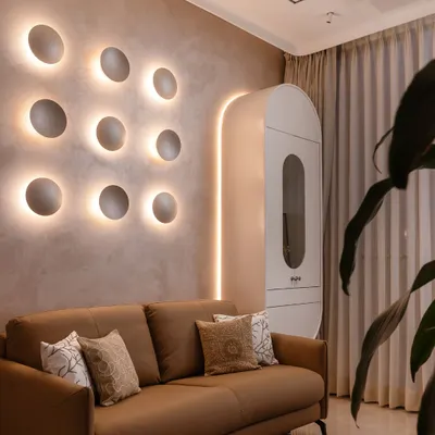 This bedroom is an exercise in soft luxury. I used a palette of grounded neutrals and sculpted textures, like the backlit concave discs on the wall, to create a space that feels both artistic and deeply calming.