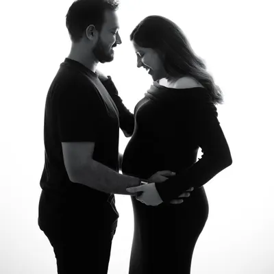A simple silhouette in black and white can tell the most powerful story. This image captures the shared joy and anticipation between two people about to become parents.
