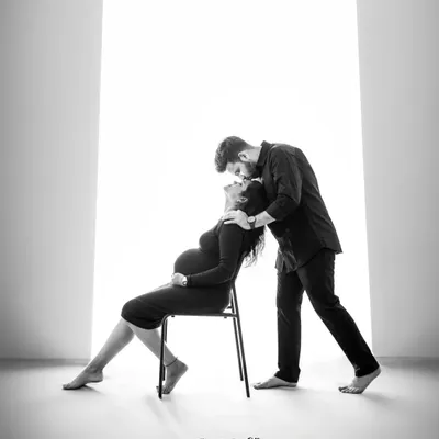 A quiet, powerful moment between a couple, captured in black and white. This artistic shot uses dramatic lighting to highlight the connection and anticipation, creating a timeless piece of art.