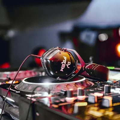 An artistic shot of my custom headphones resting on a Pioneer DJ turntable. This represents my commitment to using high-quality, reliable equipment for every performance.