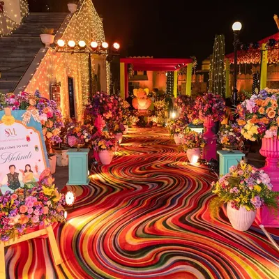 A kaleidoscope of colors for a Mehendi walkway at Shiv Niwas Palace. I used a custom-printed swirling carpet and overflowing floral arrangements to create a joyful and high-energy entrance for the guests.