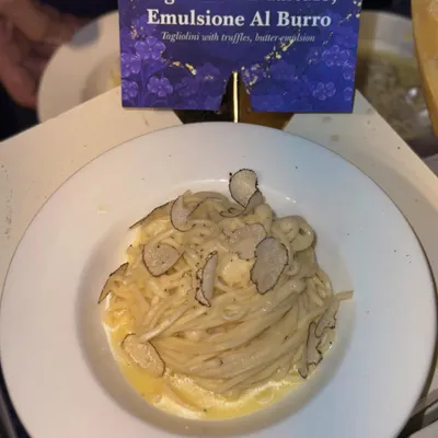 A classic Italian delight: Tagliolini Al Tartufo. This dish features fresh pasta in a butter emulsion, generously topped with shaved black truffles for an earthy, luxurious flavour.