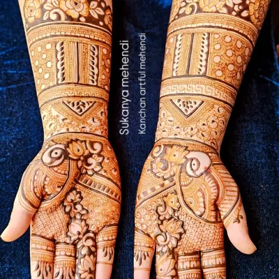 A full bridal look featuring stunning peacock figures and detailed floral work. The design extends up the arm with beautiful bands and patterns, perfect for a grand wedding celebration.