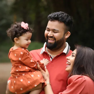 The sound of pure joy. This candid photo of a family sharing a laugh in a beautiful garden setting is what outdoor sessions are all about. It's real, it's full of love, and it's a memory frozen in time.