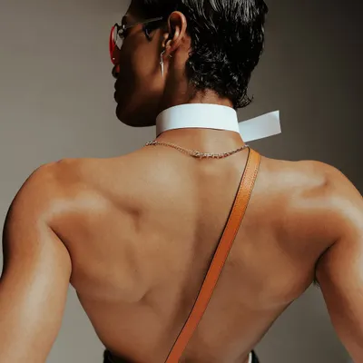 A detail-oriented shot for Calvin Klein, focusing on the product and the model's form. The angle highlights the brand's signature waistband and the texture of the accessories.