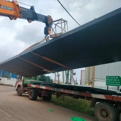 A large, prefabricated panel for the Tiruppur Business Hub is lifted into place. These panels are made from recycled PET bottles, making them lightweight, sustainable, and allowing for rapid on-site assembly.