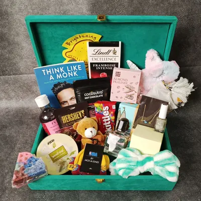 A luxurious hamper packed and ready to be sent to Mumbai. This large green velvet box is filled to the brim with books, chocolates, skincare, and more.