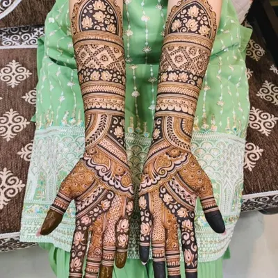 A beautiful example of a full-coverage design using geometric and floral patterns. The symmetry and clean lines create a very elegant and traditional bridal look.