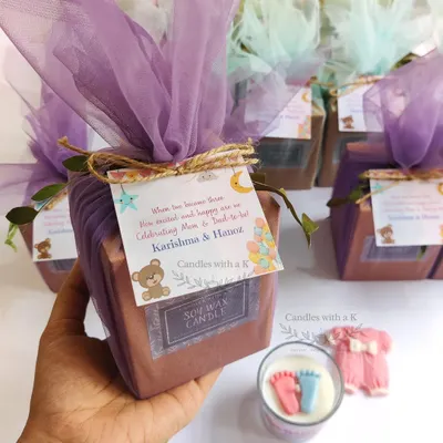 A complete gift set for Karishma's baby shower, featuring a votive candle with tiny baby feet and a baby onesie wax sachet, all wrapped in a beautiful teddy bear theme.