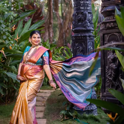 Another angle from our outdoor architectural shoot, this image captures the magnificent flow of the Kanchipuram silk saree. The movement adds life and energy, creating a stunning portrait of the mother-to-be in her element.