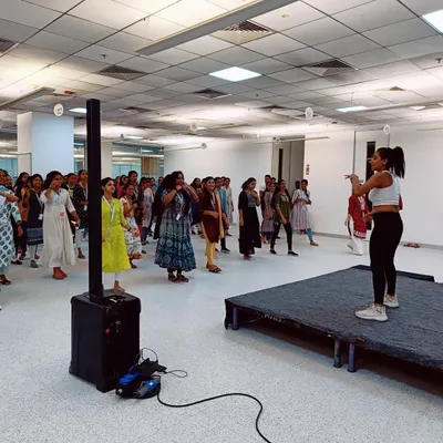 Here I am on stage, guiding the employees at Optum through a dance fitness routine. Using a small stage helps ensure everyone can see the moves, even in a large crowd, making the session effective and engaging for all.