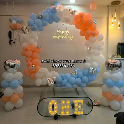 This modern ring-shaped balloon backdrop with a 'Happy Birthday' neon sign is perfect for a stylish first birthday. The 'ONE' marquee letters add a special touch.