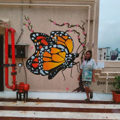 And just when they thought they could keep the caterpillar inside a cage, she began to fly again. Me standing proudly next to the finished monarch butterfly mural on a building terrace in Bandra.