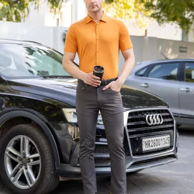 A male model wearing a short-sleeved apricot shirt and dark trousers, captured in a sharp, outdoor lifestyle shot for a commercial brand. This demonstrates my clean and professional e-commerce photography style, perfect for apparel catalogs.