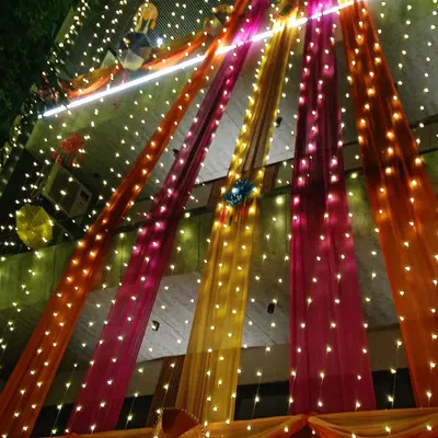 This is the nighttime view of a full home transformation. The combination of bright drapes and glowing fairy lights creates an unforgettable festive atmosphere for your wedding week.