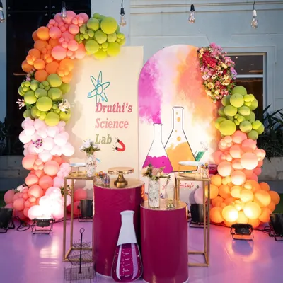 A creative and colorful "Science Lab" theme for a curious birthday kid. This setup features a vibrant balloon arch, custom backdrops with flask illustrations, and themed props to create a fun, educational party atmosphere.