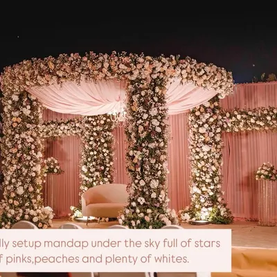 A beautifully setup mandap under a sky full of stars. We used hues of pinks, peaches, and plenty of whites to create this romantic, open-air floral mandap for a truly magical wedding ceremony.