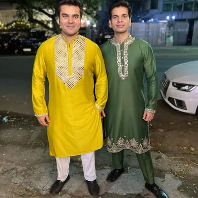 Custom kurtas that match the festive vibe. On the left, a yellow mul-mul kurta with hand-embroidered leather work, and on the right, a green version with similar intricate detailing.
