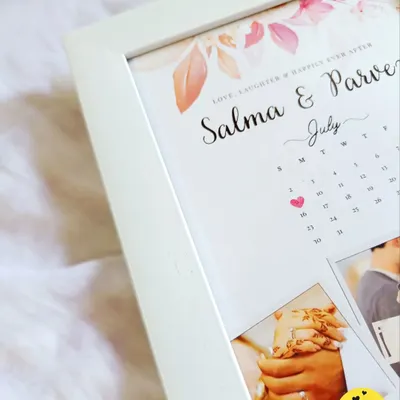 A close-up of a beautiful engagement calendar frame, highlighting the marked special date and the delicate floral design. It's a perfect way to remember the day you said "yes."