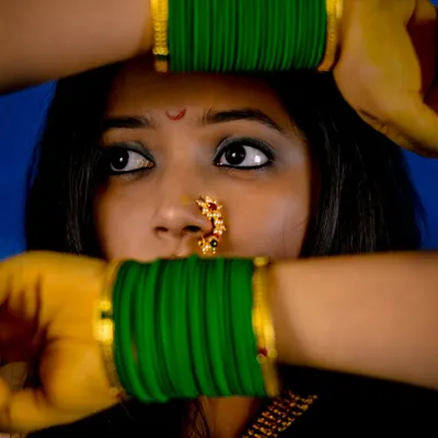 The power of styling! This look is inspired by the traditional Marathi 'Nauvari' saree look, focusing on the iconic green bangles, the 'nath' (nose ring), and the 'chandrakor' bindi.