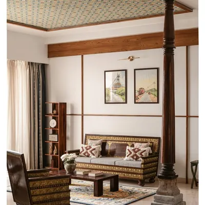 We designed this living room around the family's antique furniture, letting its history be the anchor. A Chettinad pillar adds structural grace, while the wallpapered ceiling brings a layer of subtle pattern to the space.