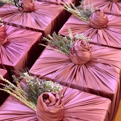 The unboxing experience is paramount. Here, I used a beautiful dusty rose fabric to wrap these gifts, creating a soft, luxurious texture. The wrapping is finished with a delicate floral sprig, transforming a simple box into an elegant and memorable present before it's even opened.