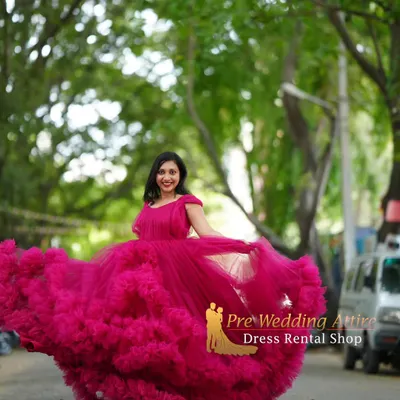 This magenta ruffled gown creates a beautiful, full silhouette, perfect for a maternity shoot with a touch of magic. The twirling motion shows off the incredible volume and flow of the layered tulle skirt.