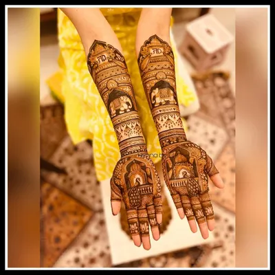 A beautiful engagement mehendi design reaching up to the forearms. This piece features personalized initials, majestic elephants, and traditional jharokha patterns, telling a unique story for the bride-to-be.