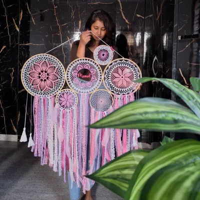 This personalized pink cluster dreamcatcher, featuring the name 'Meenal', was designed to radiate warmth and positivity. It's a perfect example of our large-scale, custom wall hangings.
