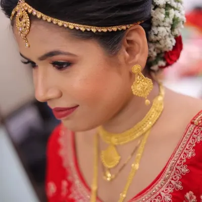 A close-up of this bride's wedding day makeup. The look features warm, coppery tones on the eyes, a classic red lip, and a flawless base that glows.
