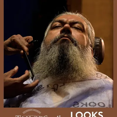 Even a long, full beard requires expert care to look its best. Here, my specialist is performing a precision trim with a straight razor, carefully shaping the beard to maintain its length while ensuring clean lines and a healthy appearance.