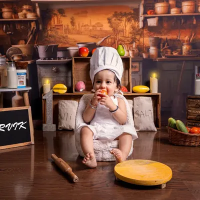 A full view of the 'Little Chef' setup, featuring a rustic kitchen backdrop, miniature sacks of flour and salt, and a personalized slate. This baby is ready to cook up some cuteness.