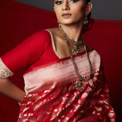 The complete royal bride ensemble. The makeup is balanced to complement the rich red and gold of the Banarasi saree, creating a look that is both majestic and deeply rooted in tradition.