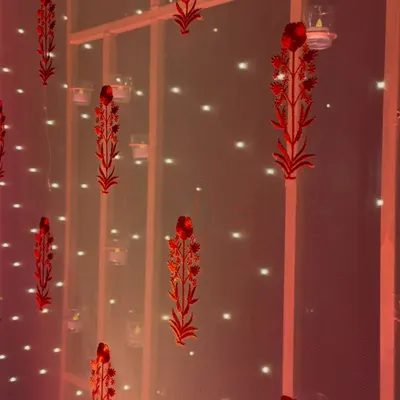 Simplicity in details. Red laser-cut floral motifs and tea lights create a delicate, heritage-inspired backdrop for a sangeet night.