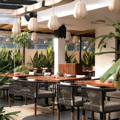 I believe a restaurant should feel like an escape. For this heritage bungalow project, I designed an outdoor seating area with a retractable pergola, lush greenery, and custom banana fiber lights to create a refreshing, tropical ambiance day and night.