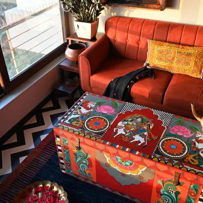 A restored vintage trunk serves as a stunning coffee table, its surface alive with hand-painted Kalamkari motifs. This piece shows how functional furniture can also be a collectible work of art, bringing heritage and color into a modern living space.
