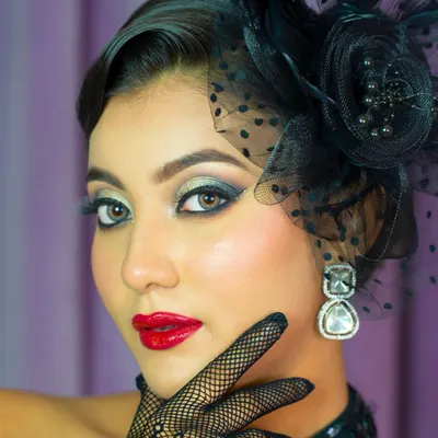 A close-up of a vintage-inspired editorial look. The sharp, smoked-out eyes, classic red lip, and flawless skin are key elements of this high-fashion style.