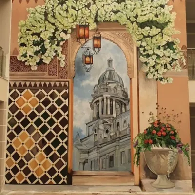 For a clubhouse in Nambiar Bellezea, we created this stunning, large-scale mural to evoke the charm of a Spanish boulevard. The artwork features a grand doorway, sun-kissed architecture, and lush flowers, creating a perfect photo opportunity.
