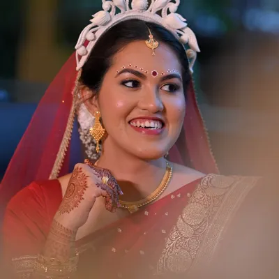 The timeless elegance of a Bengali bride. For Piyashi, who was nervous about makeup, I created a second-skin look with simple kolka designs and soft gold hues on the eyelids to complement her red Banarasi saree and traditional mukut.