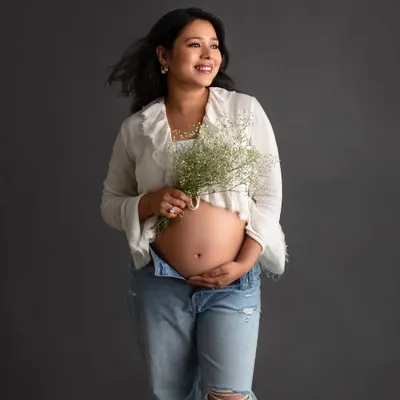 I absolutely love this breezy and carefree look. A simple white top, unbuttoned jeans, and a bouquet of baby's breath create such a fresh and modern maternity portrait.