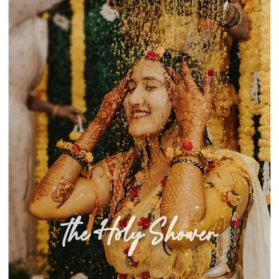 A blissful moment under 'The Holy Shower' of turmeric and flowers. We capture the peak of the Haldi ceremony with all its energy and tradition.