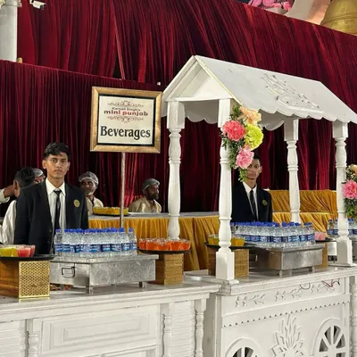 Our beverage carts are designed to be both functional and beautiful. This charming white cart, staffed by our professional servers, offers a refreshing welcome to guests at an outdoor event.