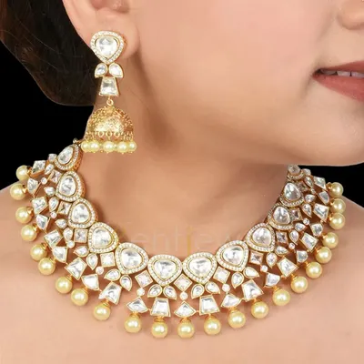 A timeless classic, this Kundan choker with delicate pearls and matching jhumka earrings is perfect for any wedding event. It adds grace and elegance without being overwhelming.